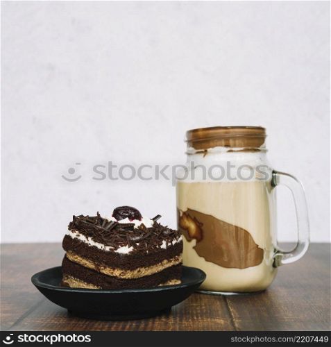 chocolate smoothie jar with slice cake wooden table
