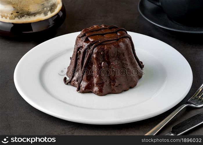 Chocolate souffle on white porcelain plate on dark stone table
