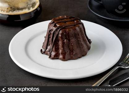 Chocolate souffle on white porcelain plate on dark stone table