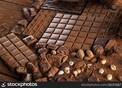 Chocolate sweet, cocoa pod and food dessert background. Dark homemade chocolate bars and cocoa pod on wooden