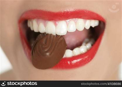 Chocolate sweet in beautiful woman mouth macro