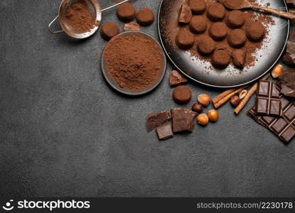 Chocolate truffles candies and cocoa powder on dark concrete background or table. Chocolate truffles candies and cocoa powder on dark concrete background