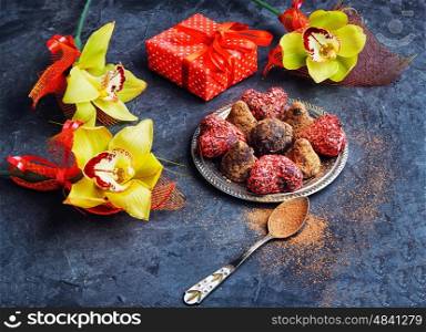 Chocolate truffles with cocoa and nuts and red box with gift. Chocolate truffles balls