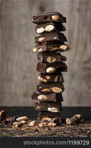 chocolate with almonds forming a tower, with shavings and broken pieces on the floor