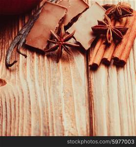Chocolate with spices - anise, vanilla, cinnamon on the wooden background