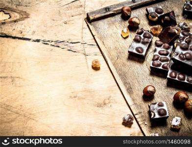 Chocolate with whole nuts. On wooden background.. Chocolate with whole nuts.