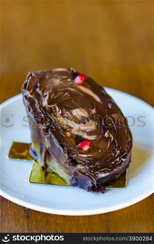Chocolate yule log cake . Chocolate yule log cake with red pomegranate