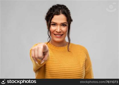 choice and people concept - portrait of happy smiling young woman with pierced nose pointing finger to camera over grey background. smiling young woman pointing finger to camera