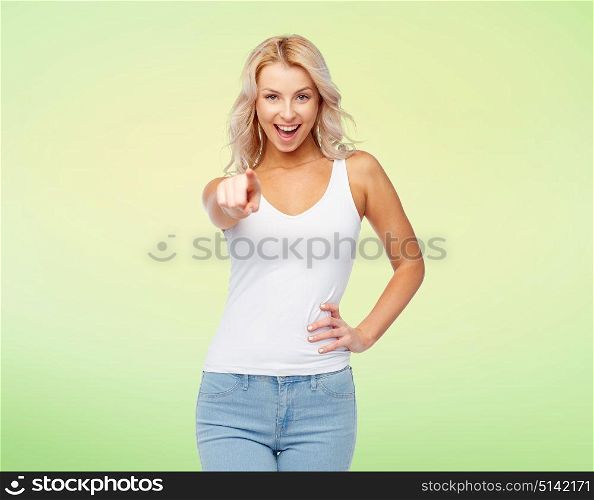 choice, fashion and people concept - happy smiling beautiful young woman in white top and jeans with blonde hair over green background. happy smiling young woman with blonde hair