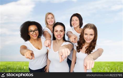 choice, friendship, body positive, gesture and people concept - group of happy different size women in white t-shirts pointing finger on you over blue sky and grass background