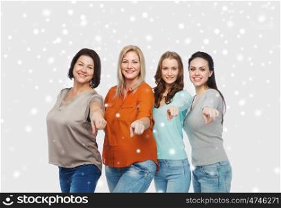 choice, friendship, fashion, diverse people concept - group of happy plus size women in casual clothes pointing finger on you over snow