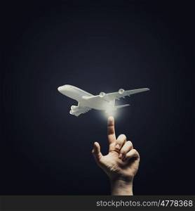 Choice your flight. Human hand pressing with finger touch screen airplane button