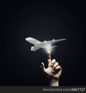 Choice your flight. Human hand pressing with finger touch screen airplane button