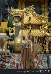 Chonburi, Thailand - 05 Feb 2022 : Chinese golden dragon sculpture decorate on incense burner chinese-style temple. Selective focus.