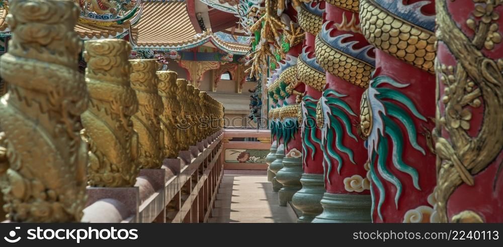 Chonburi, Thailand - 05 Feb 2022 : Panoramic of Sculptured dragons pillars and corridor in Chinese-style temple. Wihan Thep Sathit Phra Ki Ti Chaloem, Selective focus.