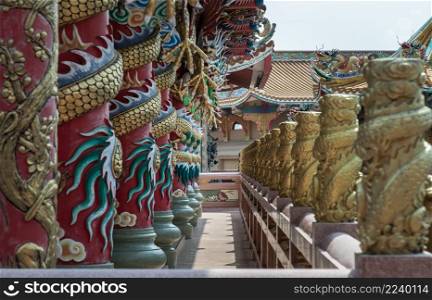 Chonburi, Thailand - 05 Feb 2022 : Sculptured dragons pillars and corridor in Chinese-style temple. Wihan Thep Sathit Phra Ki Ti Chaloem, Selective focus.
