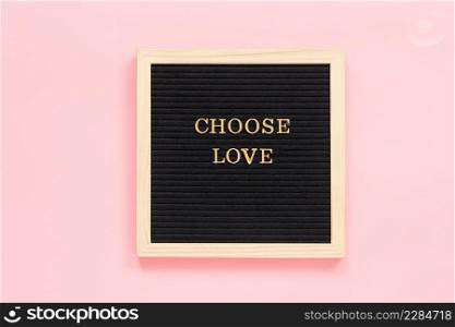 Choose love. Motivational"e in gold letters on black letter board on pink background, central composition . Top view Concept inspirational"e of the day. Template for Valentine card, postcard.. Choose love. Motivational"e in gold letters on black letter board on pink background, central composition . Top view Concept inspirational"e of the day. Template for Valentine card, postcard