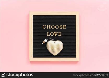 Choose love. Motivational quote in gold letters and textile heart on black letter board on pink background. Concept inspirational quote of the day. Template for Valentine card, postcard. Top view.. Choose love. Motivational quote in gold letters and textile heart on black letter board on pink background. Concept inspirational quote of the day. Template for Valentine card, postcard. Top view