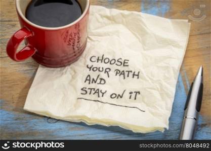 Choose your path and stay on it - motivational handwriting on a napkin with a cup of coffee