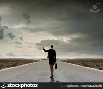 Choose your way. Back view of businesswoman standing on crossroads and making choice