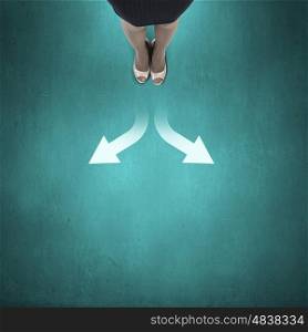 Choosing right direction. Top view of businesswoman feet standing at crossroads