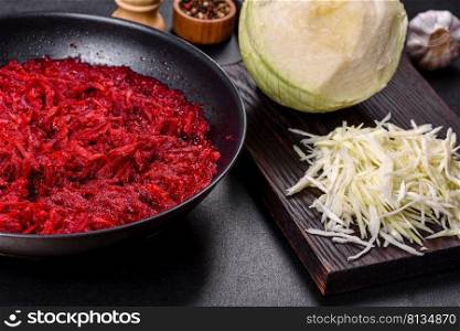 Chopped beetroot in a pan as well as sπces and herbs on a wooden cutting board as ingredients in the pre¶tion of traditional Ukrainian borscht. Chopped beetroot in a pan as well as sπces and herbs on a wooden cutting board