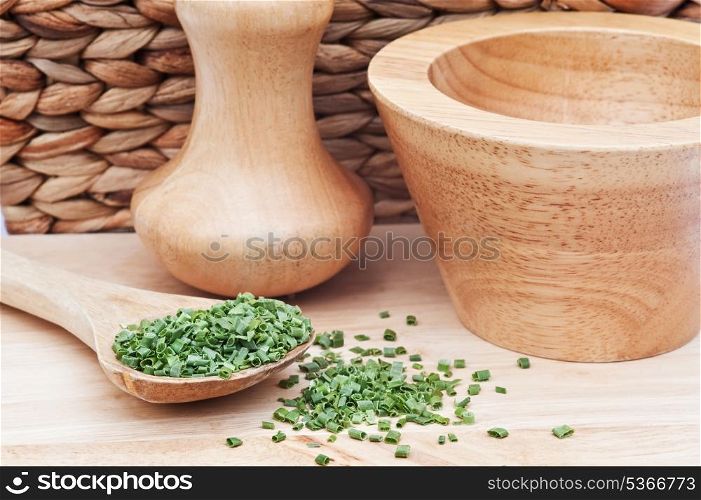 Chopped chives in rustic kitchen scene with wooden utensils