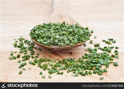 Chopped chives on wooden serving spoon with shallow depth of field