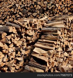 Chopped fire wood stacked in a pile as a symbol of country living using renewable resources from the forest as cut tree logs.