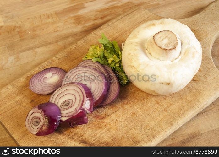 Chopped fresh raw onion and mushroom on a wooden board