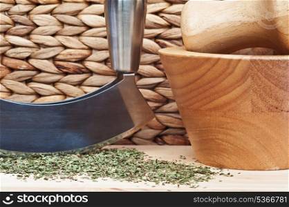 Chopped mint leaves in rustic kittchen setting with herb chopperr and pestle and mortar