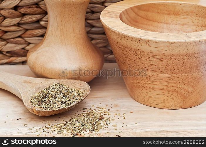chopped oregano marjoram leaves in rustic kitchen setting with wooden utensils