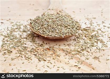 Chopped rosemary on wooden serving spoon with shallow depth of field