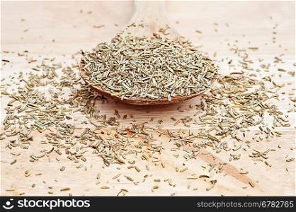 Chopped rosemary on wooden serving spoon with shallow depth of field