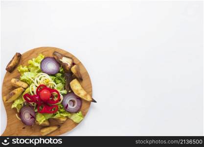 chopped vegetables roasted potato wooden cutting board white background