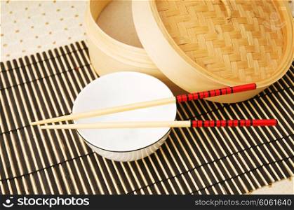 Chopsticks and bowl on the bamboo mat