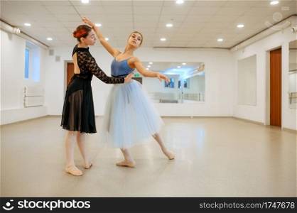Choreographer works with young ballerina in class. Ballet school, female dancers on choreography lesson, girls practicing grace dance. Choreographer works with young ballerina in class