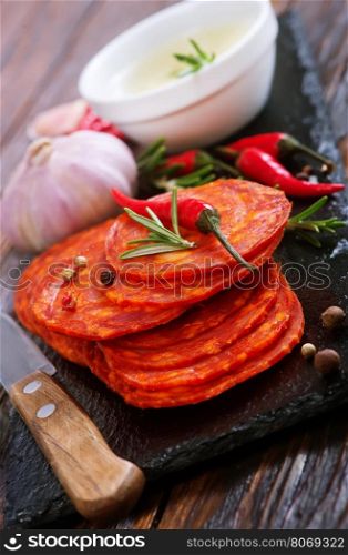 chorizo on wooden board and on a table