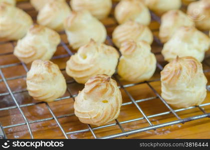 choux cream. fresh choux cream on a cooling grid over wooden table