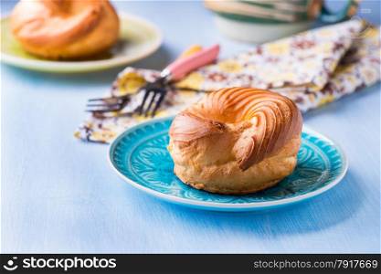 Choux pastry eclair ring with custard cream served for tea, selective focus