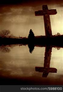 Christian cross and the clouds with water reflection