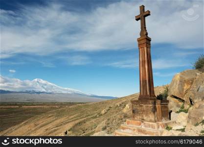 Christian cross in ancient monastery Khor Virap near Turkish-Armenian border in front of Ararat mountain