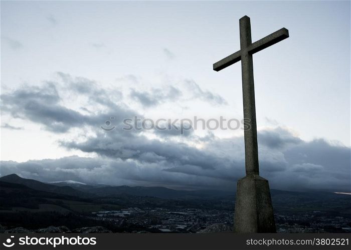 Christian cross silhouette on the top of the mountain. Bray, Ireland.