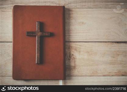 Christian cross with the holy bible on wooden , Vintage Christian Cross, Concept of hope , christianity , faith, religion and church online.