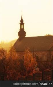 Christian religion. Tower of the small brick church at sunset or sunrise. Place of worship.