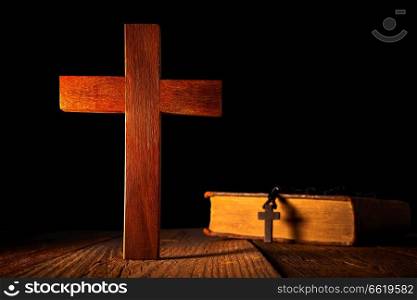 Christian wood cross on black wooden made with Bible and rosary beads