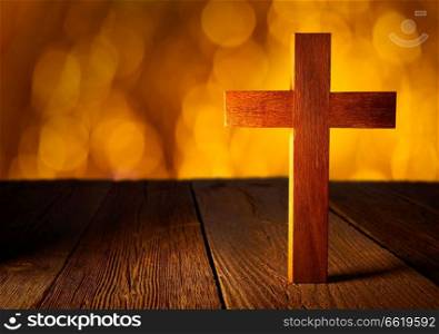 Christian wood cross on blur flare lights and wooden background