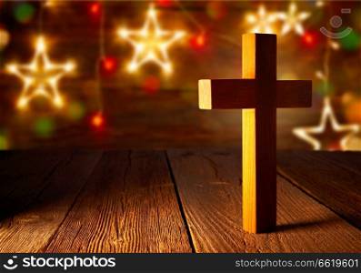 Christian wood cross on Christmas stars wooden background