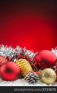 christmas accessories and spheres on snow on red background