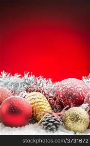 christmas accessories and spheres on snow on red background